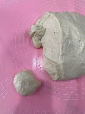 发酵好的面团移到案板上,揉圆排气,然后按自己的需求分成不同大小的剂子,我是分了以下三种规格:
50g做小餐包、 80g做长条卷包、240g做辫子包
 分好的面团揉圆,盖保鲜膜松弛15分钟。