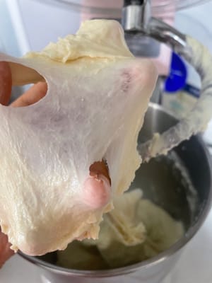 开低速和面,先把粉类搅到没有颗粒,再转高速揉到能拉出锯齿状的膜(这是扩展阶段)。