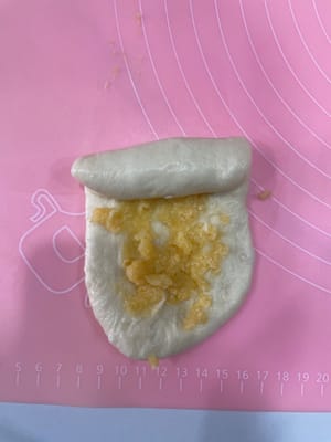 80g长条卷包:
把面团擀成长条,均匀抹上一层椰蓉馅,卷起来。
一个250g的一次性面包盒里,刚好放3个卷好的面团。