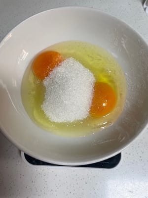 趁发酵的时候做椰蓉馅(好吃的灵魂)
鸡蛋、牛奶、白糖倒一起搅打均匀,再加入低筋面粉翻拌到没有干粉,有点小面疙瘩也不怕,等下炒的时候会压碎。