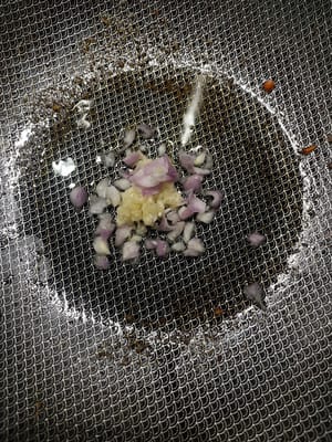 鍋熱落油倒紅蒜頭，蒜頭落去炒香