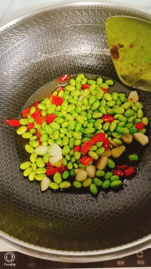 masukkan edamame yang sudah direbus ke dalam air, tambahkan sesendok kecap asin, tumis sebentar dengan cepat, lalu masukkan daging sapi potong dadu yang sudah disiapkan, aduk rata sebelum disajikan