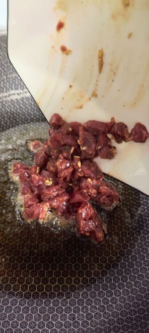 Calentar la sartén y el aceite, verter los cubos de carne marinados, sofreír rápidamente a fuego alto hasta que cambie de color y servir.