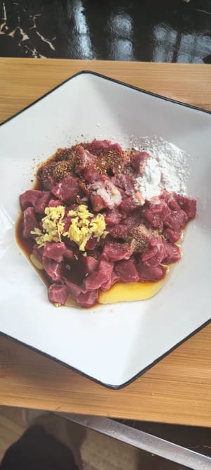 Cortar la carne limpia en cubos, agregar aceite de cocina para ablandarla, sal, salsa de soja ligera, salsa de ostras, maicena, aceite de pimienta y pimienta en polvo, mezclar bien y reservar.