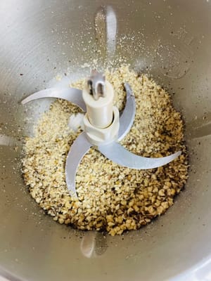 Schiacciate o schiacciate le noci e mettetele da parte. Non schiacciatele troppo finemente; qualche pezzettino le renderà più saporite.