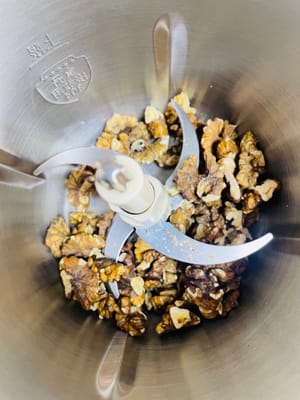 Schiacciate o schiacciate le noci e mettetele da parte. Non schiacciatele troppo finemente; qualche pezzettino le renderà più saporite.