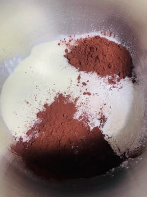 Versare la farina ad alto contenuto di glutine, il cacao in polvere, il latte in polvere, il lievito secco e il sale nella ciotola e mescolare bene.