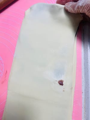 私はパスタマシンを使って生地を薄く伸ばしました。手で伸ばす場合は、厚さ2mm以下、幅25cm、長さ30cm以上に伸ばしてください。

写真参照：伸ばしたあんこシートを生地シートの半分に置き、もう半分で覆います。

手で軽く伸ばし、3分の1のところからさらに半分に折ります。

麺棒を使って軽く平らに伸ばすと、あんこが生地にしっかりと密着します。