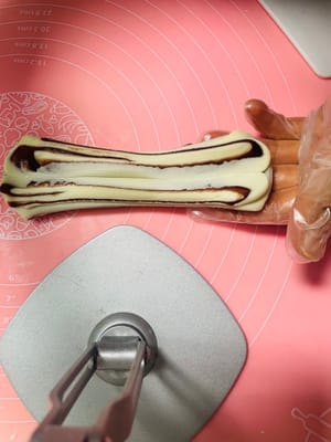 麺を15cmくらいの長さに伸ばし、箸で真ん中をねじり、両端をしっかりとつまんでから、箸で軽く押さえます。

（この手順は動画でより分かりやすく説明しています。箸は下から抜くことを忘れないでください。）