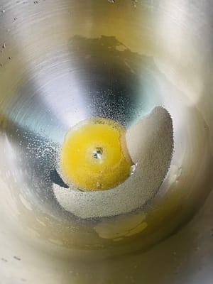 ボウルにイースト、食用油、塩、温水を入れて混ぜ、溶けたら小麦粉と砂糖を加えます。

生地が滑らかになり、べたつかなくなるまで、ドウミキサーを使うか手でこねます。