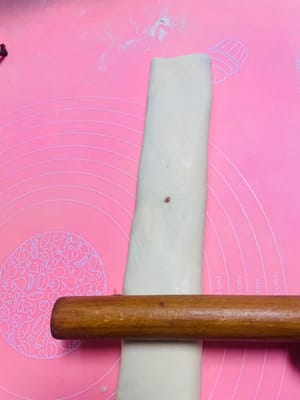 私はパスタマシンを使って生地を薄く伸ばしました。手で伸ばす場合は、厚さ2mm以下、幅25cm、長さ30cm以上に伸ばしてください。

写真参照：伸ばしたあんこシートを生地シートの半分に置き、もう半分で覆います。

手で軽く伸ばし、3分の1のところからさらに半分に折ります。

麺棒を使って軽く平らに伸ばすと、あんこが生地にしっかりと密着します。