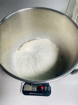 ボウルにイースト、食用油、塩、温水を入れて混ぜ、溶けたら小麦粉と砂糖を加えます。

生地が滑らかになり、べたつかなくなるまで、ドウミキサーを使うか手でこねます。