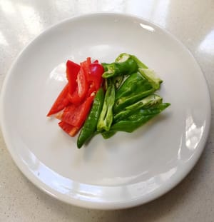 Cortar el ajo en láminas y los pimientos verdes y chiles en tiras y reservar.