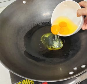 Vierta el aceite en la sartén, caliente el aceite y vierta los huevos en el bol.