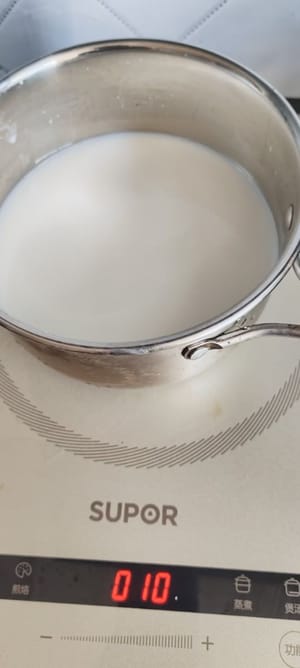 Versez le lait pur dans une casserole et faites-le chauffer à feu doux jusqu'à ce qu'il soit légèrement bouillant.