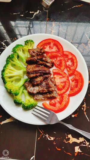Faites revenir le steak et disposez-le sur une assiette. Coupez les tomates en deux et disposez-les sur une assiette. Pour une touche sucrée, saupoudrez de sucre. Disposez les brocolis préparés dans l'assiette, dans l'ordre.