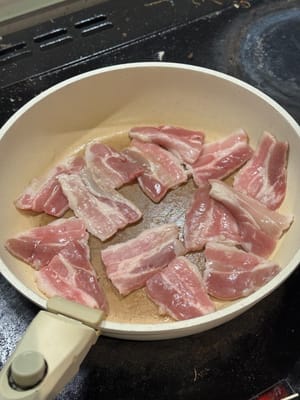 在熱鍋中，煎五花肉至滋滋作響，然後翻面。確保兩面都略為焦黃。
