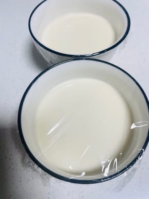 Slowly pour the sieved milk into the prepared steaming bowl (you can divide it into 2-3 bowls according to your preference), and try to pour it as steadily as possible to reduce the generation of bubbles. Then, take the plastic wrap and cover the bowl tightly, and use a toothpick to poke 5-6 small holes in the plastic wrap to facilitate the circulation of steam.