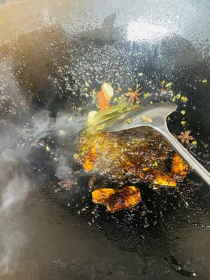 Zutaten anbraten und Brühe zubereiten. Einen Wok mit kaltem Öl bei niedriger Hitze erhitzen. Zuerst Ingwerscheiben anbraten, bis sie duften, dann Kandiszucker hinzufügen und unter Rühren karamellisieren lassen. Pixian-Chilibohnenpaste hinzufügen und unter Rühren anbraten, bis das Öl rot wird. Anschließend die restlichen Gewürze hinzufügen und unter Rühren anbraten. So viel heißes Wasser angießen, dass die Schweinshaxe bedeckt ist, und etwa 1 Esslöffel Salz hinzufügen (abschmecken; die Brühe sollte leicht salzig sein). Zum Kochen bringen und dann vom Herd nehmen. Durch das Anbraten von Zucker und Chilibohnenpaste erhält die Brühe ihre rote, glänzende Farbe, die Gewürze sorgen für einen reichhaltigeren Geschmack.