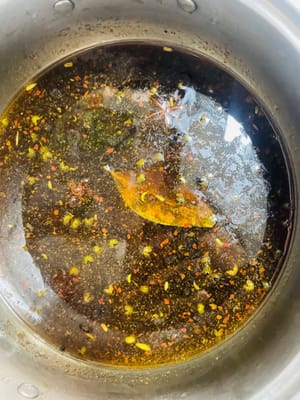 Menumis bahan-bahan dan membuat kaldu. Panaskan wajan berisi minyak dingin dengan api kecil. Pertama, tumis irisan jahe hingga harum, lalu tambahkan gula batu dan tumis hingga karamel. Tambahkan pasta kacang cabai Pixian dan tumis hingga minyak berubah warna menjadi merah. Selanjutnya, tambahkan bumbu lainnya dan tumis. Tambahkan air panas secukupnya hingga merendam kaki babi, dan tambahkan sekitar 1 sendok makan garam (cicipi; kaldu seharusnya sedikit asin). Didihkan, lalu angkat dari api. Menumis gula dan pasta kacang cabai bertujuan untuk membuat kaldu berwarna merah dan berkilau, sementara bumbu-bumbunya membuat rasanya lebih kaya.