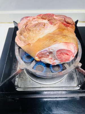 Schwarte anbraten und reinigen. Die Schwarte der Schweinshaxe goldbraun anbraten. Dadurch werden der fischige Geruch und Schmutz entfernt. Anschließend in warmem Wasser einweichen, um sie weicher zu machen, und dann die angebrannten Stellen mit einem Messer abkratzen.