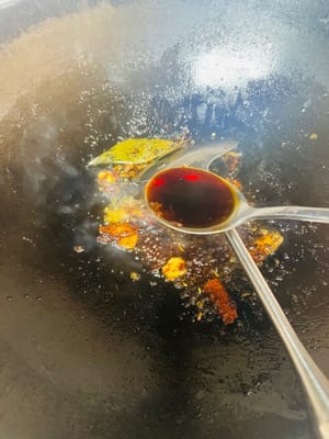 Zutaten anbraten und Brühe zubereiten. Einen Wok mit kaltem Öl bei niedriger Hitze erhitzen. Zuerst Ingwerscheiben anbraten, bis sie duften, dann Kandiszucker hinzufügen und unter Rühren karamellisieren lassen. Pixian-Chilibohnenpaste hinzufügen und unter Rühren anbraten, bis das Öl rot wird. Anschließend die restlichen Gewürze hinzufügen und unter Rühren anbraten. So viel heißes Wasser angießen, dass die Schweinshaxe bedeckt ist, und etwa 1 Esslöffel Salz hinzufügen (abschmecken; die Brühe sollte leicht salzig sein). Zum Kochen bringen und dann vom Herd nehmen. Durch das Anbraten von Zucker und Chilibohnenpaste erhält die Brühe ihre rote, glänzende Farbe, die Gewürze sorgen für einen reichhaltigeren Geschmack.