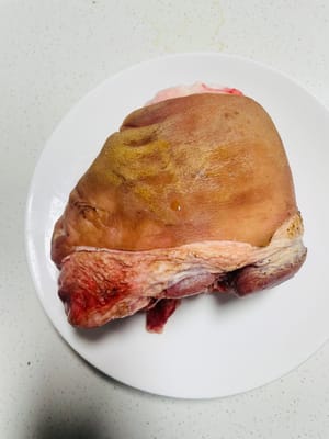 Schwarte anbraten und reinigen. Die Schwarte der Schweinshaxe goldbraun anbraten. Dadurch werden der fischige Geruch und Schmutz entfernt. Anschließend in warmem Wasser einweichen, um sie weicher zu machen, und dann die angebrannten Stellen mit einem Messer abkratzen.