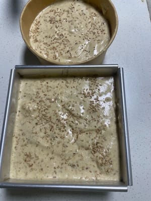 Verter y agitar: Vierta la masa en el molde hasta llenarlo al 80%. Levante el molde y golpéelo suavemente sobre la mesa varias veces para eliminar las burbujas de aire grandes. Espolvoree una capa de semillas de sésamo blanco por encima.