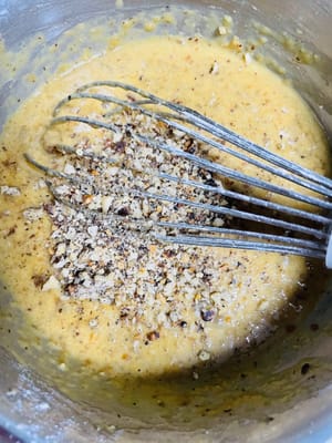 Agregar la harina y mezclar la masa: Tamizar la harina para pasteles, agregar las nueces picadas, el polvo para hornear y el bicarbonato de sodio, y mezclar hasta que no queden partículas de harina seca (puede omitir el polvo para hornear y el bicarbonato de sodio si no le gustan los agentes leudantes).