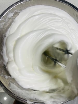 Batir claras de huevo: Añadir el zumo de limón y la maicena al bol con las claras. Añadir el azúcar a las claras en 3 tandas y batir con una batidora eléctrica hasta que se formen picos firmes (los picos deben mantenerse erguidos al levantar las varillas).