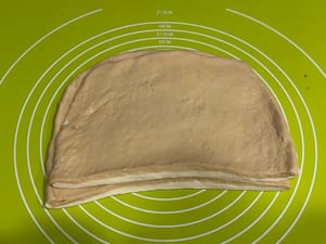 แล้ววางซ้อนกัน คุณสามารถใช้มือยืดแป้งให้สองชั้นมีขนาดเท่ากันได้