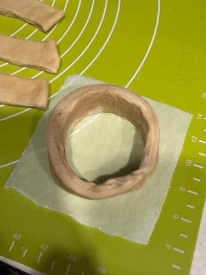 ม้วนแผ่นแป้งให้เป็นรูปวงกลมบนกระดาษไข ตรวจสอบให้แน่ใจว่าด้านที่เรียบและสวยกว่าหันออกด้านนอก เย็บปลายที่เชื่อมต่อกันให้แน่นด้วยน้ำเล็กน้อย