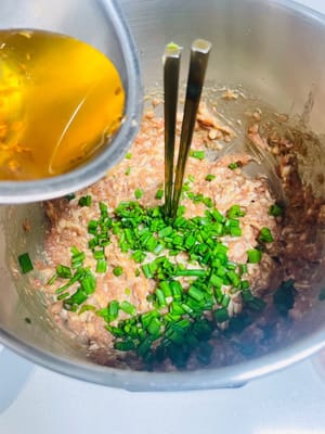 Saat isian daging diaduk dan menjadi lengket dan padat, saatnya menambahkan langkah kunci rasa! Pertama, tuangkan minyak daun bawang yang harum agar aroma daun bawang yang kuat meresap ke celah-celah di antara partikel daging; lalu tuangkan minyak wijen yang lembut, dan terakhir taburi dengan daun bawang cincang segar, dan aduk cepat hingga merata. Karena isian mengandung banyak cairan, disarankan untuk menutupnya dan mendinginkannya selama lebih dari 2 jam sebelum digunakan. Ini tidak hanya akan membuat isian menyerap aroma sepenuhnya, tetapi juga membuat teksturnya lebih padat, dan tidak mudah hancur saat dibungkus, dan produk jadi akan terasa lebih lezat dan padat.