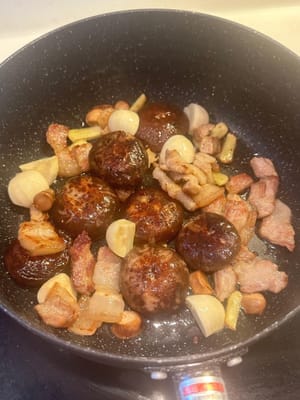 之後，加入泡好的帶柄香菇、蠔乾、扇貝以及蒜、薑。繼續翻炒。