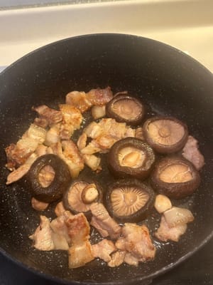 之後，加入泡好的帶柄香菇、蠔乾、扇貝以及蒜、薑。繼續翻炒。