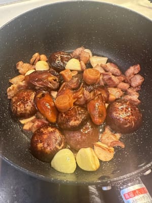 之後，加入泡好的帶柄香菇、蠔乾、扇貝以及蒜、薑。繼續翻炒。