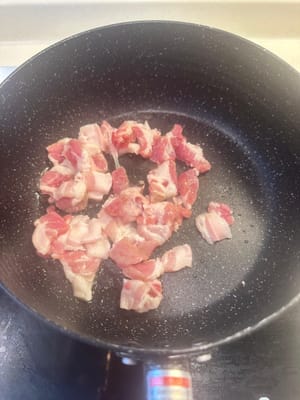 在同一個鍋中，加入切好的五花肉片，以中小火加熱。這樣做是為了逼出油脂並保留香味。