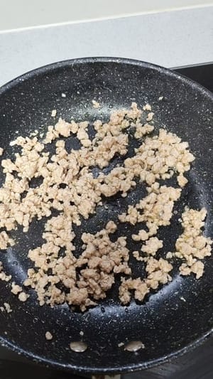 다진 고기와 버섯을 팬에 넣고 약한 불로 익을 때까지 볶습니다.
