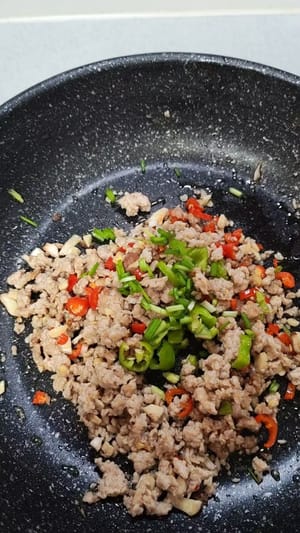 倒入蒜，薑各5克，小米椒5克。加生抽一湯匙，小火把肉末炒香後，再加100毫升的清水。加入食用鹽適量，胡椒粉少許，蠔油一茶勺，小火至開。