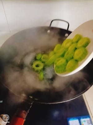 Etwas Salz und Speiseöl ins Wasser geben, die vorbereitete Bittermelone hineingeben und blanchieren.