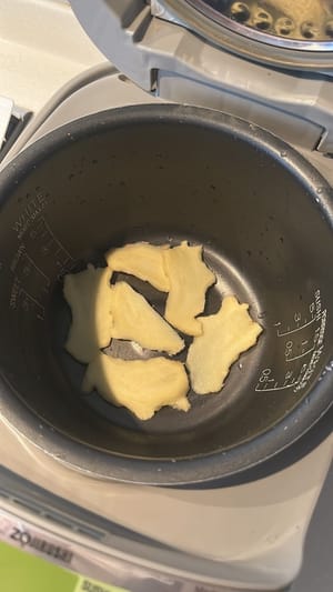 在鍋裡鋪上薑片和蔥花