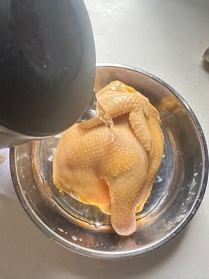 先將滾水倒在雞肉上。這一步有助於緊緻雞皮，使雞肉更嫩。之後將水瀝乾。