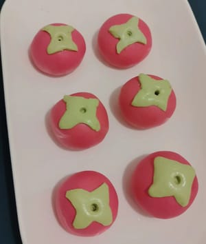 Letakkan setiap batang kesemek di atas bola-bola ketan yang telah diuleni, seperti memasang topi, dan tekan perlahan. Hiasi dengan batang kesemek.