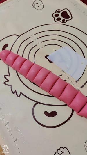 Gulung adonan menjadi strip panjang, lalu potong menjadi beberapa bagian yang sama panjangnya.