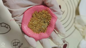 Ambil bola adonan mentah, gulung hingga berbentuk bulat, pipihkan dengan pemotong adonan, masukkan isian, jepit pinggirannya untuk menutupnya, lalu gulung kembali hingga berbentuk bulat dengan telapak tangan.