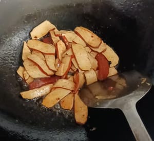 Etwas Öl in die Pfanne geben, den getrockneten Tofu dazugeben und unter Rühren anbraten, bis die Ränder leicht angebraten sind.