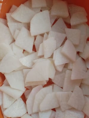 Pelar el rábano blanco, lavarlo, cortarlo en rodajas y ponerlo en un bol junto con las rodajas de jengibre. Marinarlo con sal durante dos minutos. Enjuagar y filtrar el rábano marinado con agua, añadir azúcar blanca y marinar durante un minuto.