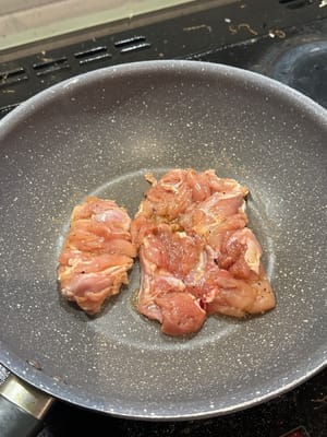 在熱鍋中，將醃製好的雞肉煎至酥脆金黃