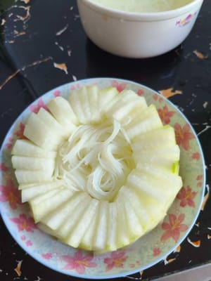 Die Fadennudeln in die angerichteten Wintermelonenscheiben geben.