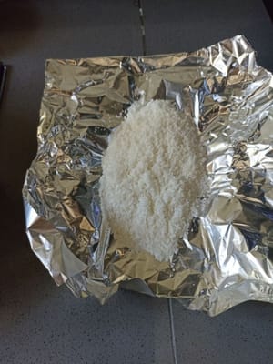 Nehmen Sie 10 g trockene Kokosraspeln und dämpfen Sie diese.